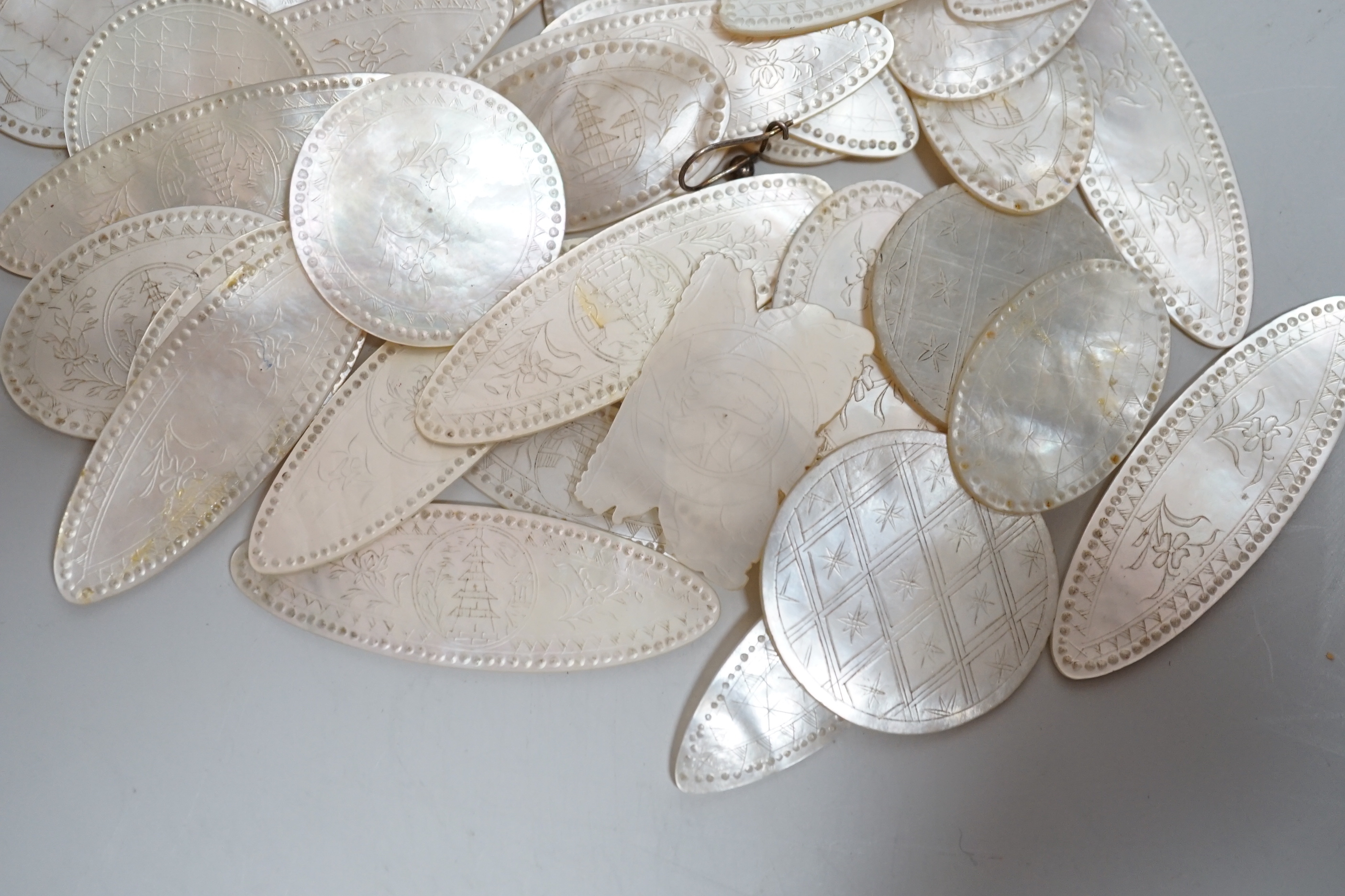 A collection of Chinese mother of pearl counters or tokens including two converted to drop earrings, the largest 5cm wide